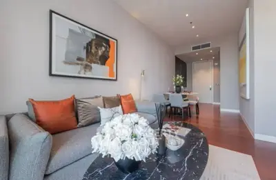 Stylish modern living room with elegant decor and dining area, featuring contemporary artwork and plush seating.