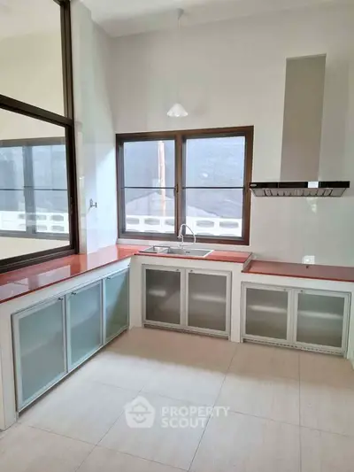 Modern kitchen with sleek cabinetry and large windows for natural light