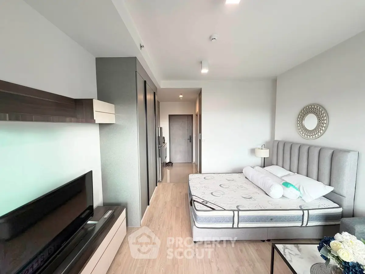 Modern bedroom with stylish decor and natural light, featuring a comfortable bed and sleek furniture.