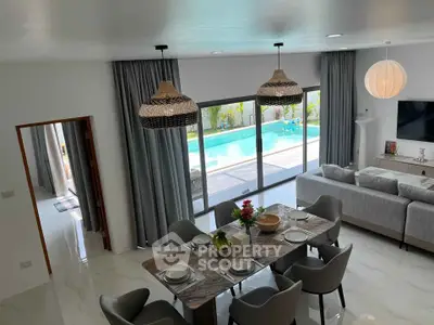 Luxurious open-plan living room with pool view, elegant dining area, and modern decor.