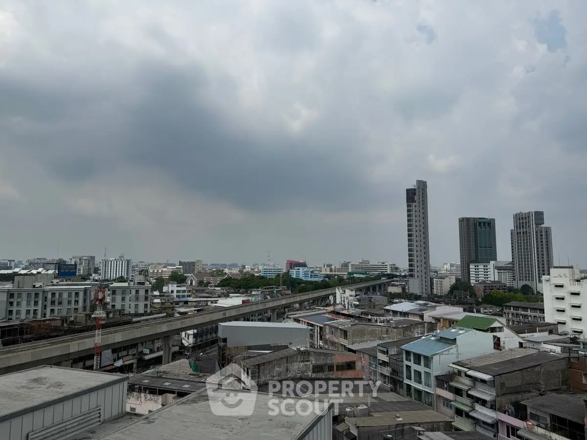 Panoramic cityscape view with high-rise buildings and cloudy sky, showcasing urban living.