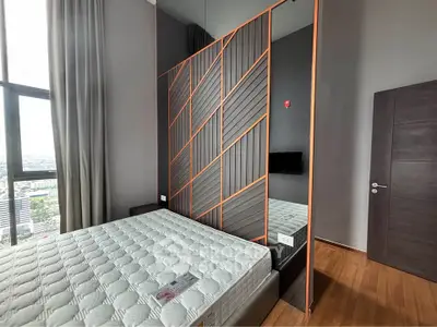 Modern bedroom with stylish partition and city view, featuring a comfortable bed and sleek wooden flooring.