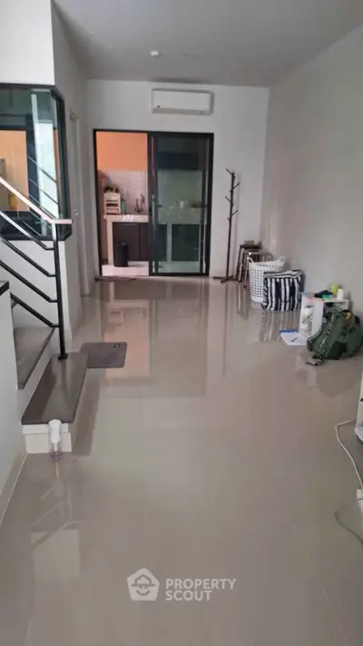 Spacious modern interior with sleek flooring and staircase, ideal for contemporary living.