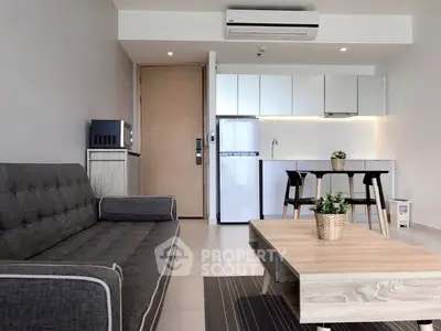Modern living room with sleek kitchen, stylish furniture, and contemporary design in open layout apartment.