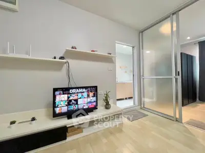 Modern living room with TV and sliding glass door, showcasing sleek design and cozy atmosphere.