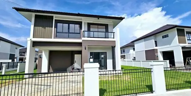 Modern two-story house with spacious lawn and sleek design in a serene neighborhood.