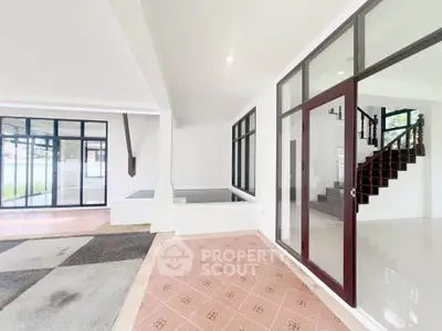 Spacious modern interior with large windows and elegant staircase
