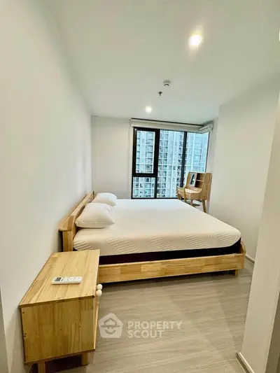 Modern bedroom with wooden furniture and city view from large window