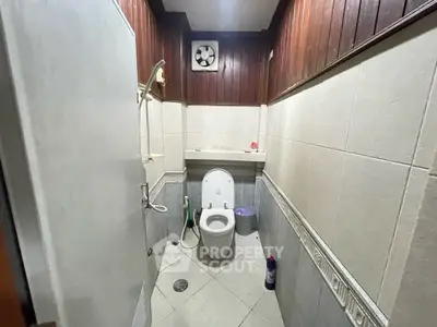 Compact bathroom with wooden paneling and modern fixtures