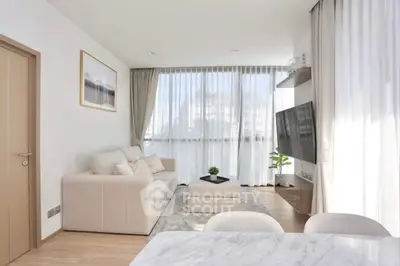 Modern living room with large windows, elegant decor, and natural light.