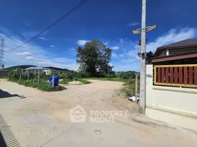 Spacious vacant land with clear blue sky, ideal for new construction in a serene neighborhood.