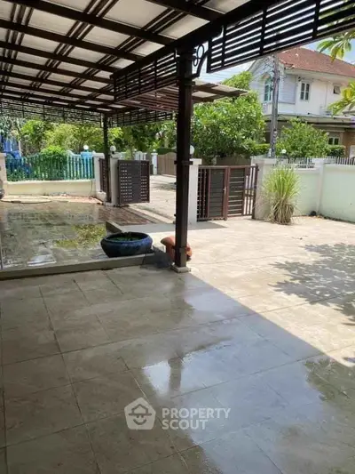 Spacious outdoor patio with tiled flooring and garden view, perfect for relaxation.