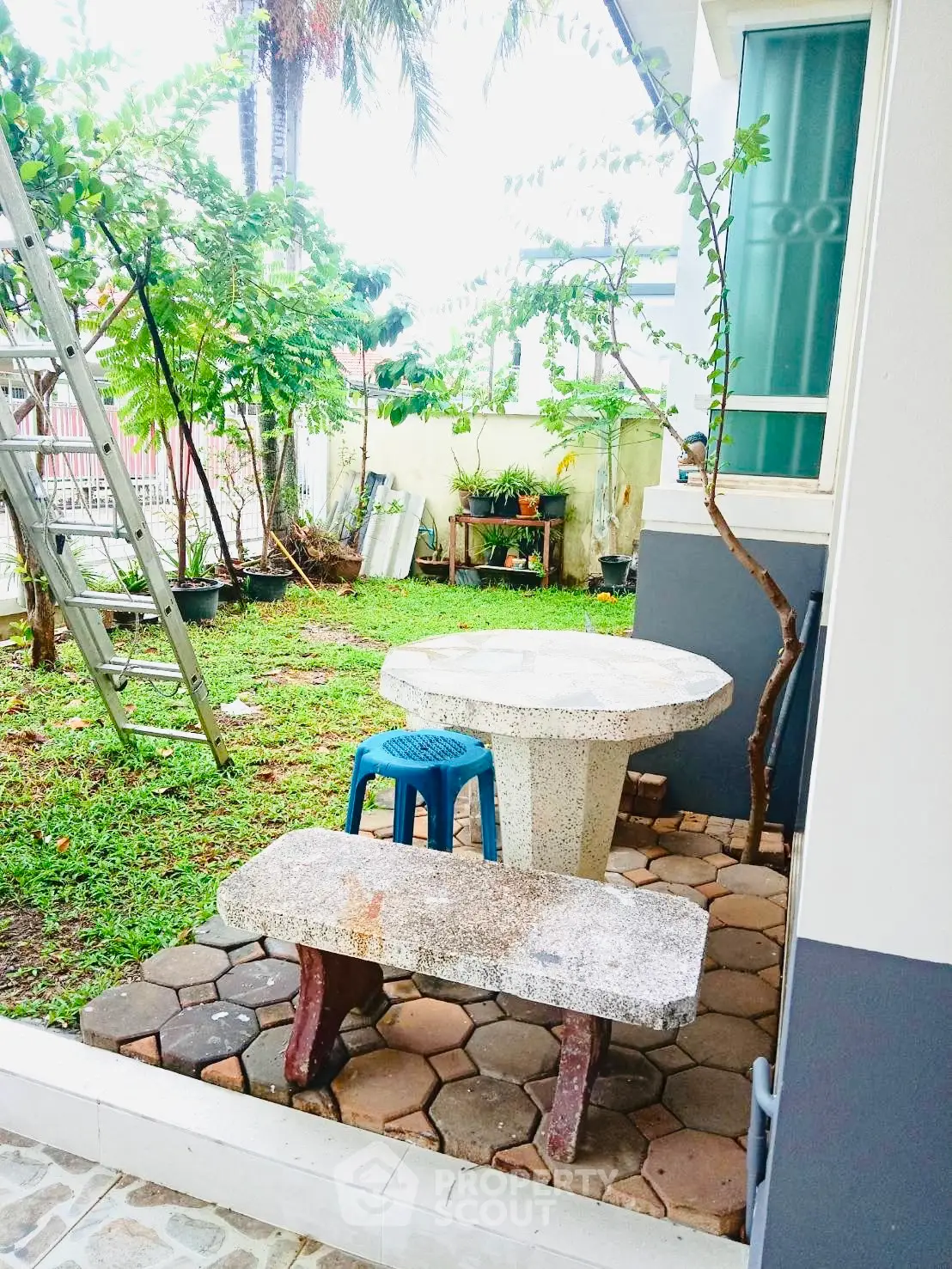 Charming garden area with rustic stone table and benches, perfect for outdoor relaxation and gatherings.