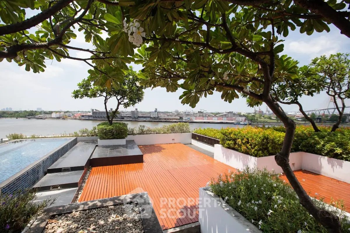 Stunning rooftop terrace with river view and lush greenery, perfect for relaxation and entertainment.