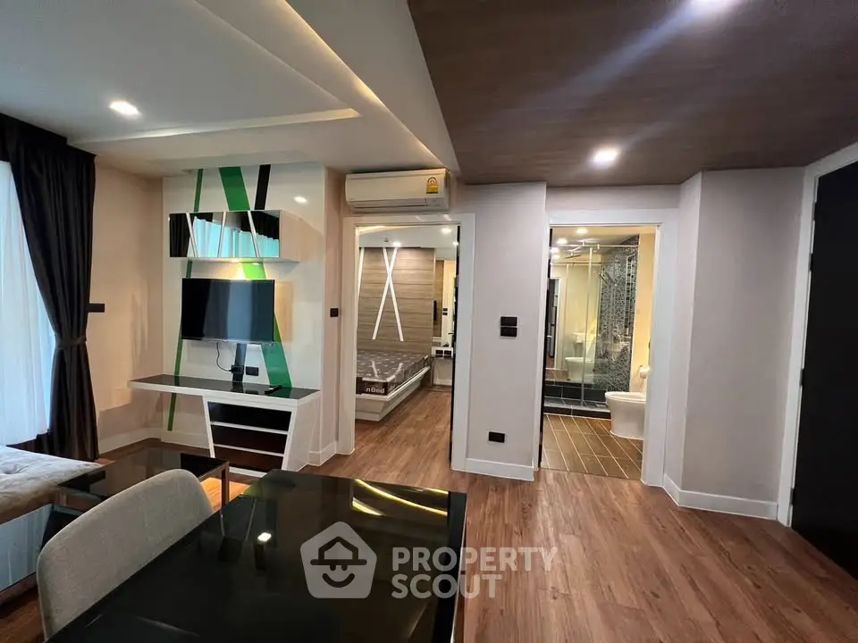 Modern open-plan living room with stylish decor and view into luxurious bathroom