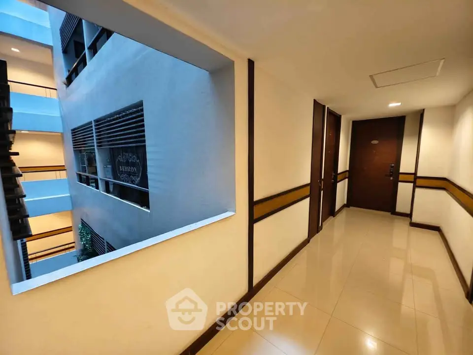 Modern apartment hallway with polished floors and ambient lighting