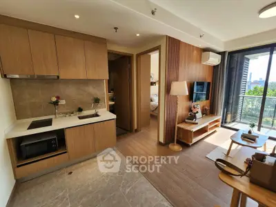 Modern open-layout kitchen and living room with balcony view in a stylish apartment.
