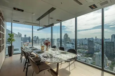 Luxurious dining area with panoramic city views in a modern high-rise apartment.