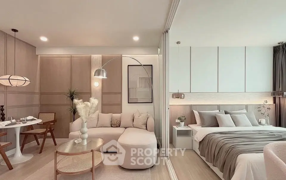 Modern open-plan living room and bedroom with stylish decor and neutral tones.