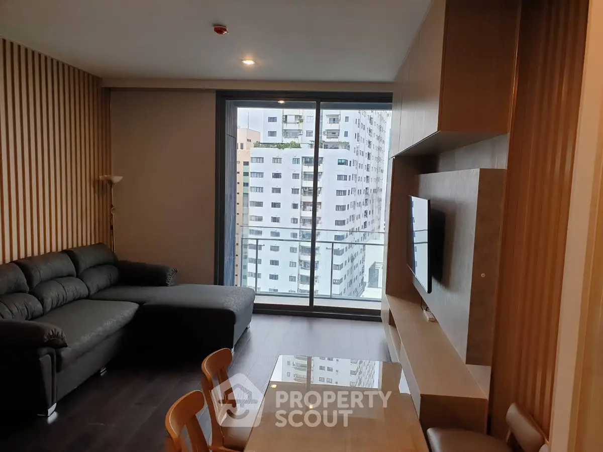 Modern living room with city view, featuring sleek furniture and large windows for natural light.