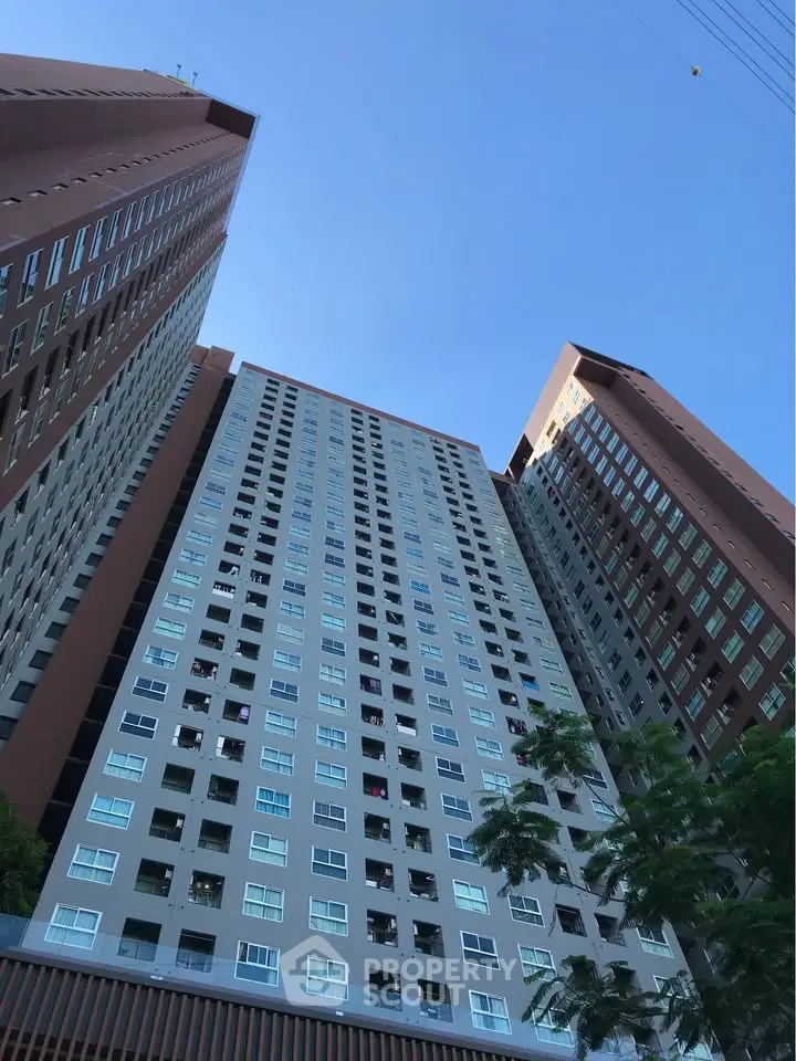 Stunning high-rise building exterior with modern architecture and clear blue sky backdrop.