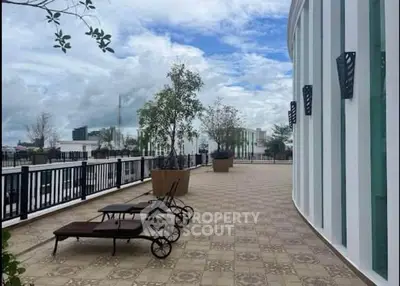 Spacious rooftop terrace with lounge chairs and potted plants, offering a serene outdoor retreat.