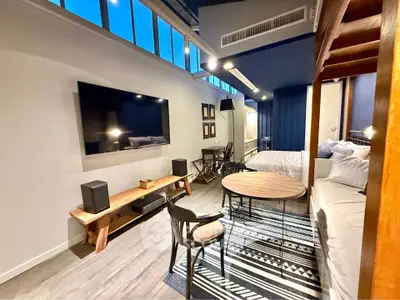 Modern studio apartment with stylish decor and large wall-mounted TV
