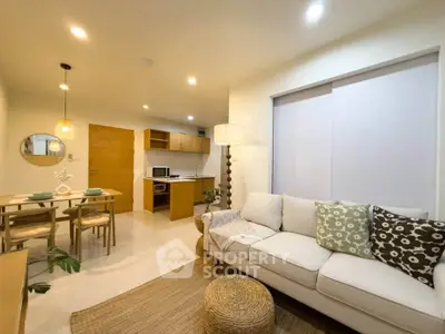 Modern open-plan living room with cozy sofa and stylish dining area in a contemporary apartment.