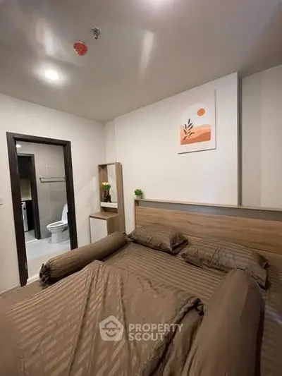 Cozy bedroom with modern decor and ensuite bathroom in a stylish apartment.