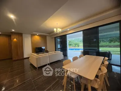 Spacious modern living room with elegant dining area and scenic outdoor view.