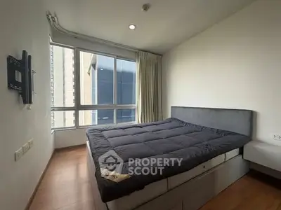 Modern bedroom with large window and cozy bed in urban apartment