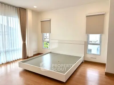Spacious bedroom with modern design and large windows for natural light.
