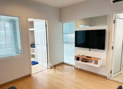 Modern living room with wall-mounted TV and sleek wooden flooring