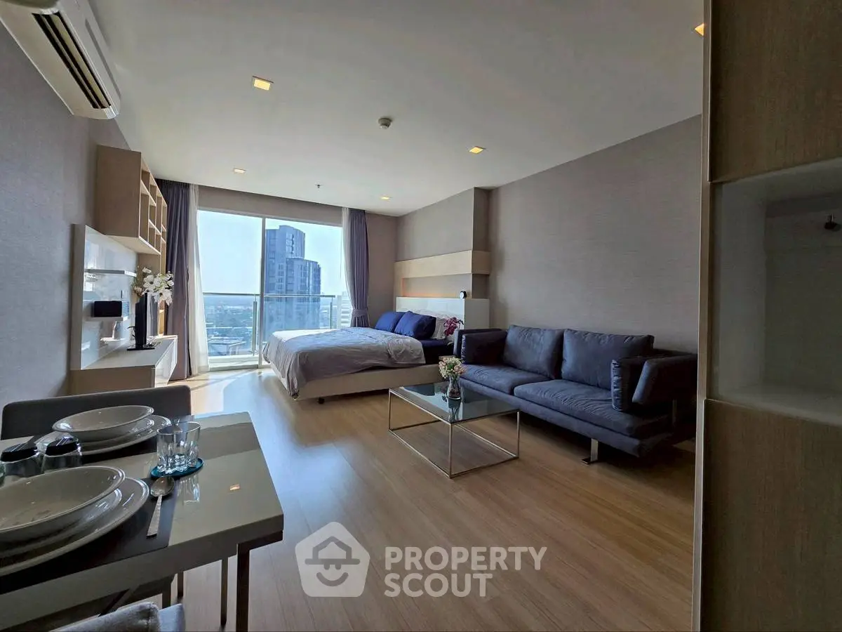 Modern studio apartment with city view, featuring cozy living area and elegant decor.