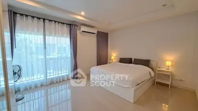 Spacious modern bedroom with large windows and elegant decor in a luxury apartment.