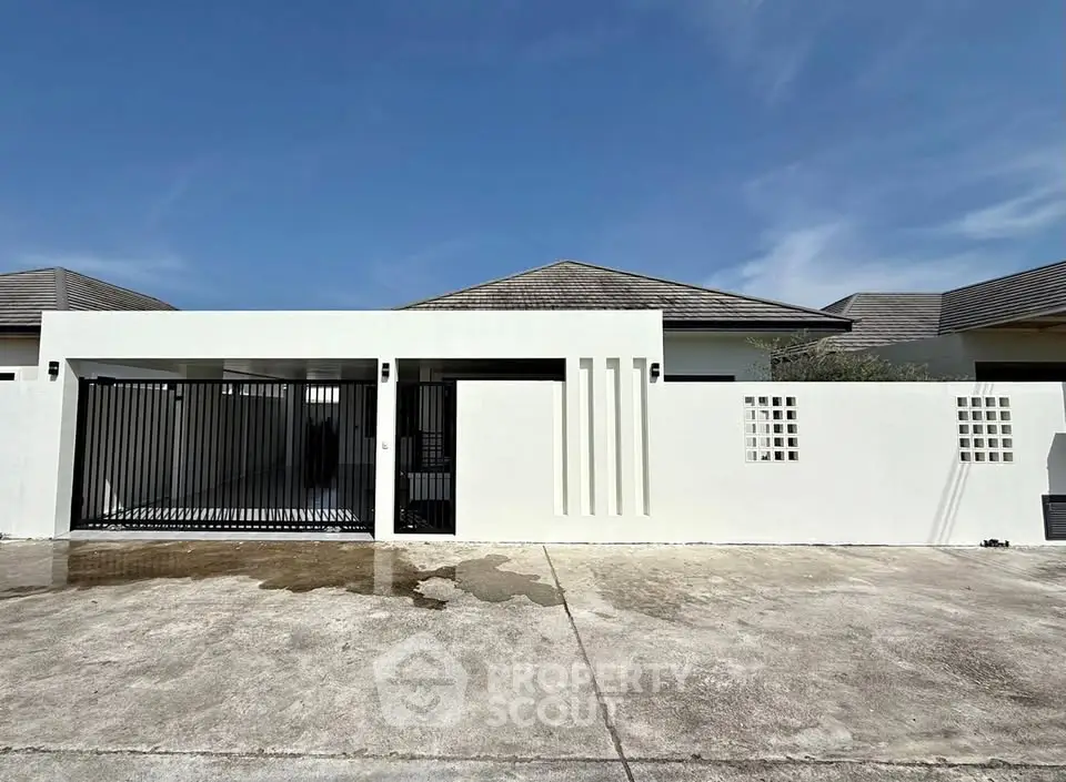 Modern minimalist house exterior with sleek design and gated entrance