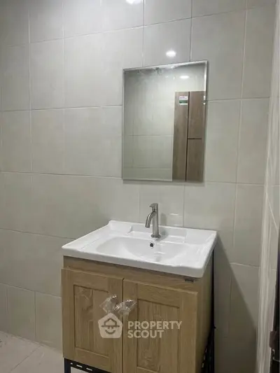 Modern bathroom with sleek vanity and mirror in a stylish real estate property.