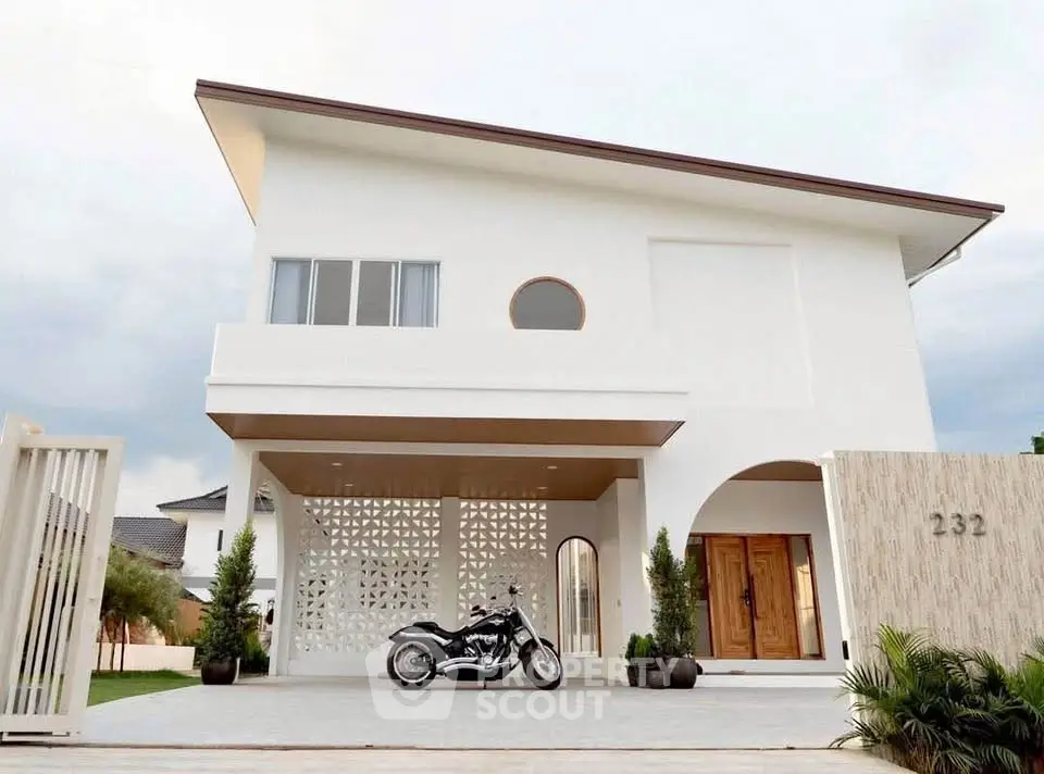 Modern minimalist white house with unique architecture and motorcycle parked in driveway.