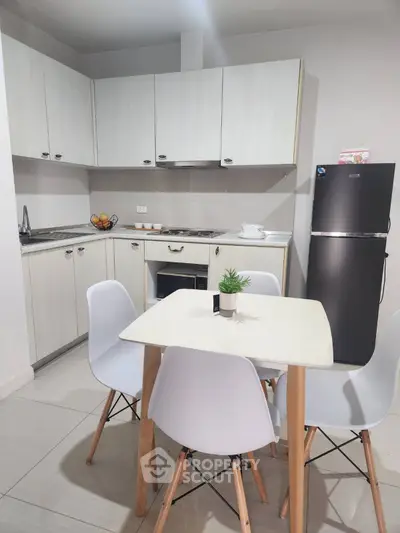 Modern kitchen with sleek cabinets and dining area in a stylish apartment.