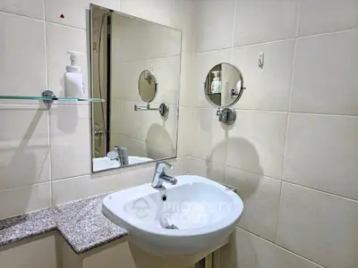 Modern bathroom with sleek sink and mirror in a stylish real estate property.