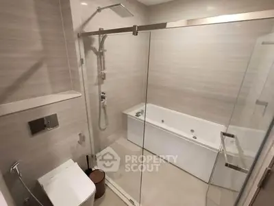 Modern bathroom with glass shower and bathtub in luxury apartment