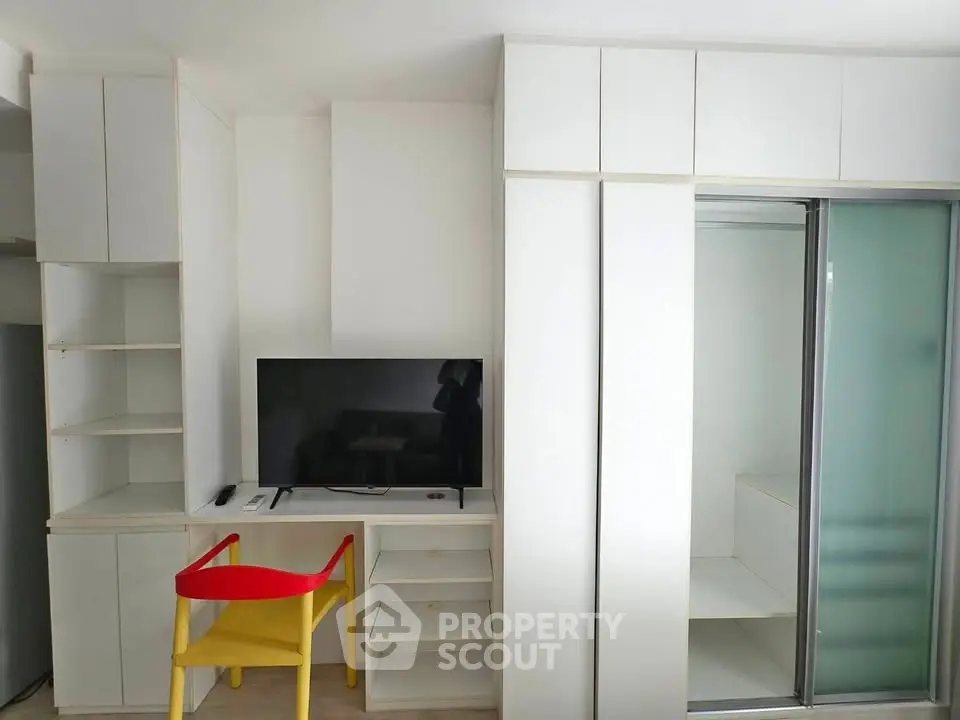Modern minimalist living room with built-in storage and vibrant yellow chair