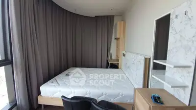 Modern bedroom with large window and stylish furniture in a contemporary apartment.