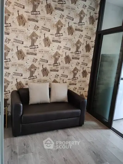 Chic living room with stylish New York-themed wallpaper and cozy black sofa.