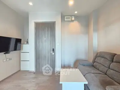 Modern living room with sleek furniture and wall-mounted TV, showcasing minimalist design.