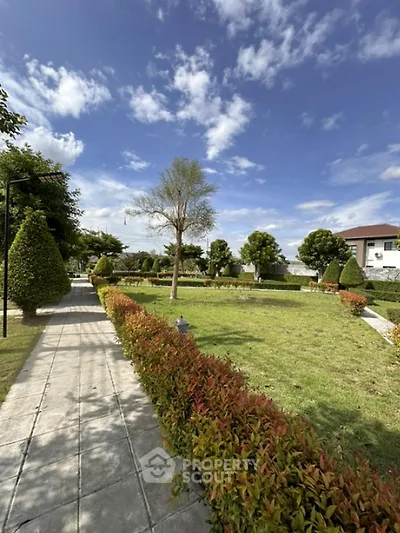 Beautiful landscaped garden with lush greenery and clear blue sky in a residential area.