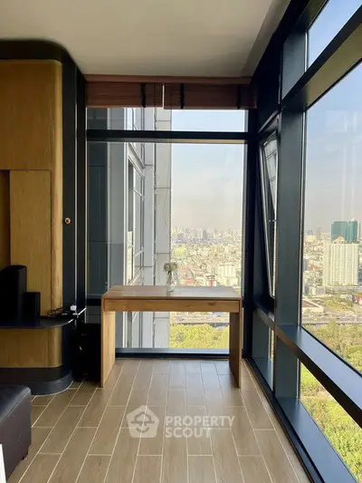 Stunning corner unit with floor-to-ceiling windows offering panoramic city views, perfect for a home office.