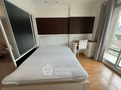 Spacious bedroom with wooden flooring and balcony view in modern apartment
