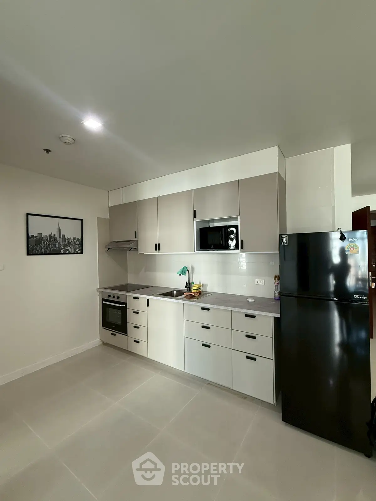 Modern kitchen with sleek cabinetry and stainless steel appliances in a spacious apartment.