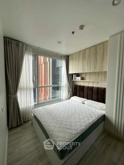 Modern bedroom with large window and stylish decor in urban apartment